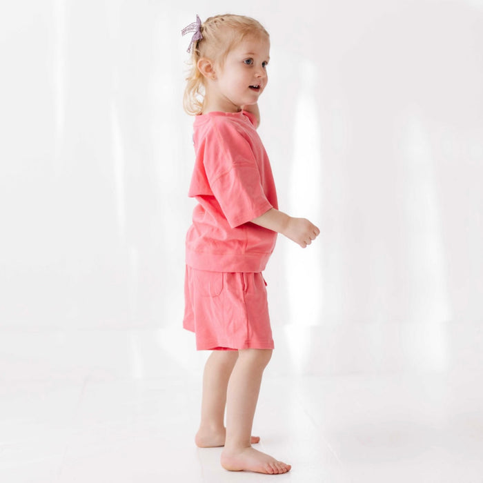Young girl wearing a pink outfit on a white background