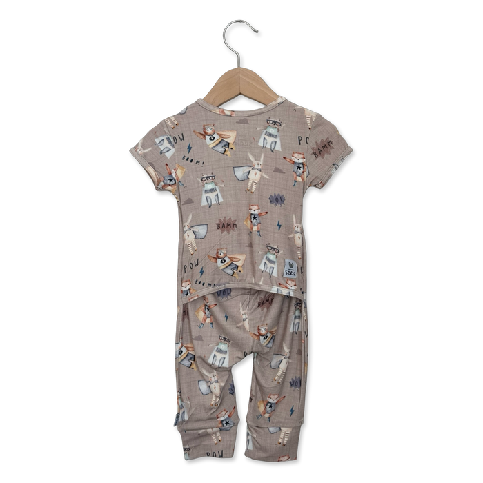 Children's pajama set with animal print on a hanger against a white background