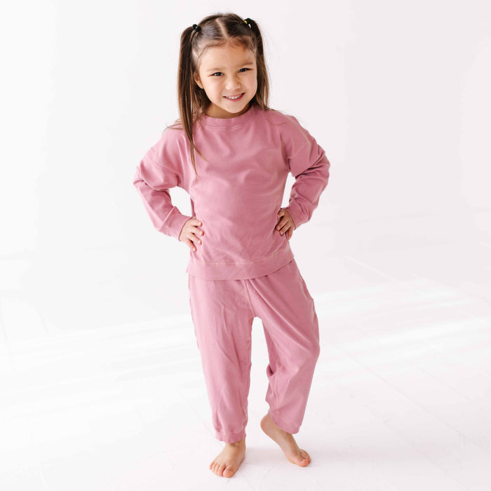 Young girl wearing pink pajamas on a white background