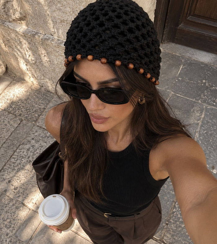Black crochet beanie with brown beaded trim, worn with sunglasses