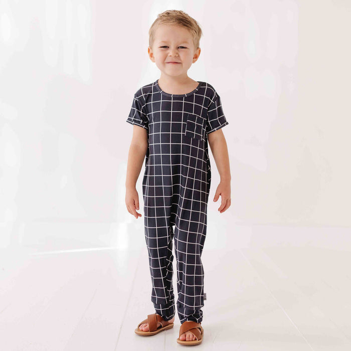 Child wearing a black and white checkered outfit on a white background