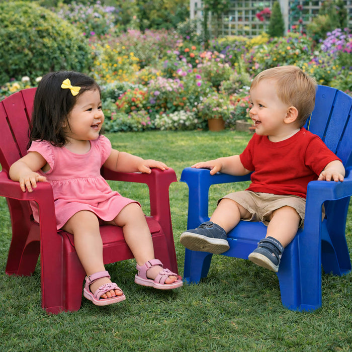 Two children sitting on red and blue chairs in a garden