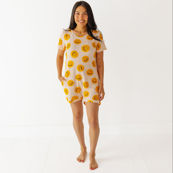 Woman wearing a short-sleeve dress with smiley face pattern on a white background