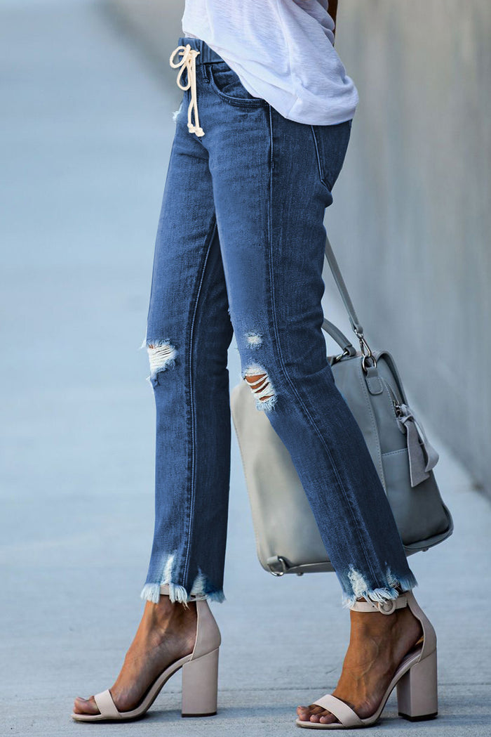 Jean bleu foncé à taille élastique, jambe droite, ourlet brut détruit