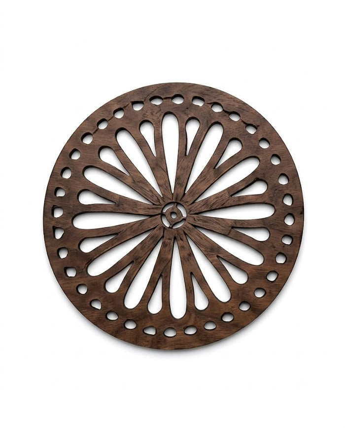 Round dark brown wooden trivet with sunflower-inspired perforated design, polished edges