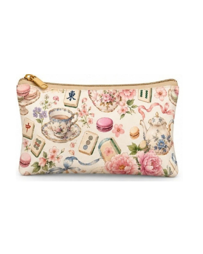 Tea-themed zip pouch with gold zipper and pastel teacup, flower, and macarons print.