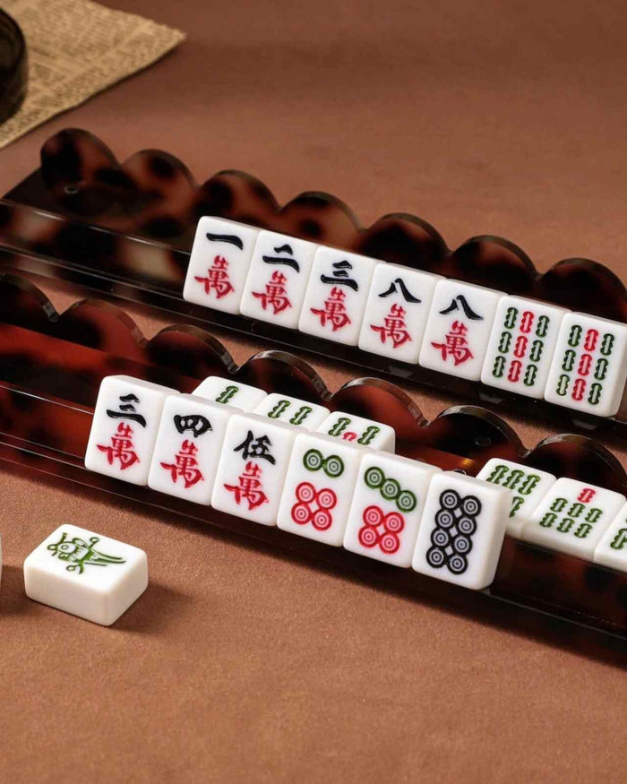 Tortoise shell acrylic mahjong racks with white tiles and Chinese suit symbols