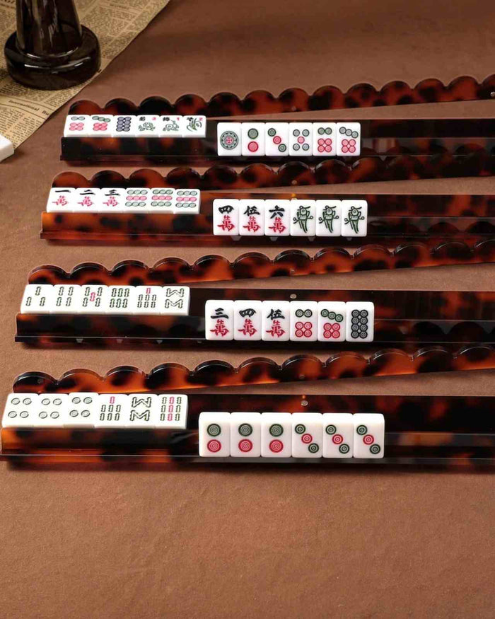Tortoise shell acrylic mahjong racks holding white tiles, close-up view
