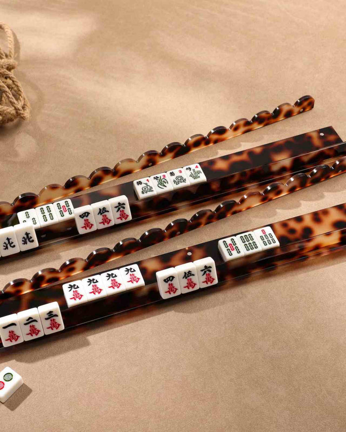 Close view of tortoise shell acrylic mahjong racks with white tiles on ledges