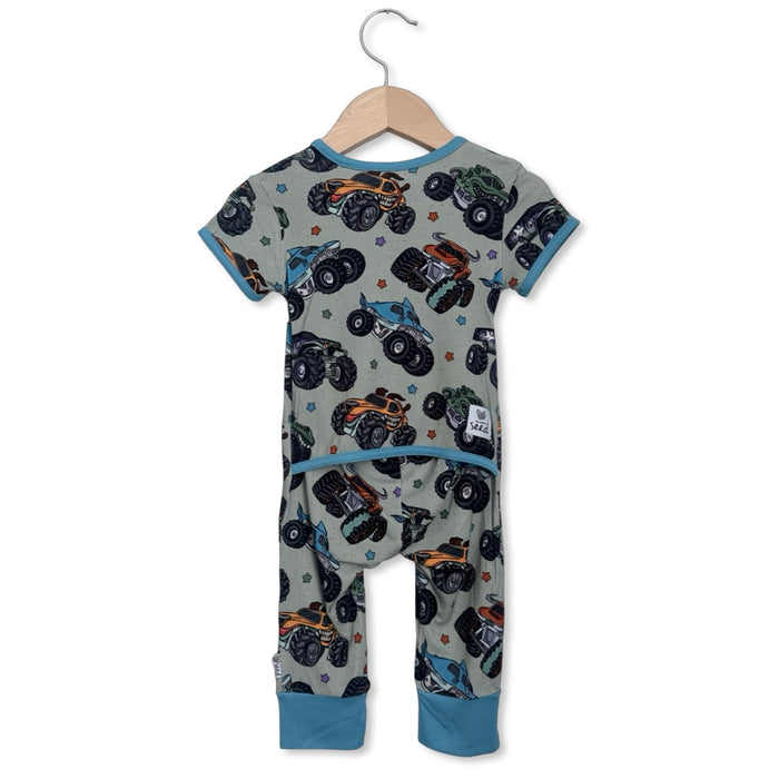 Children's onesie with monster truck pattern on a hanger against a white background